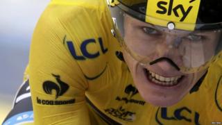 Chris Froome grits teeth while cycling in yellow jersey