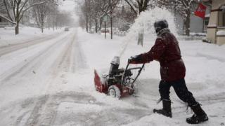 Kevin Pokorny works on his third house clearing snow for neighbour's in Barrington, Ill., Thursday, Jan. 2, 2014.