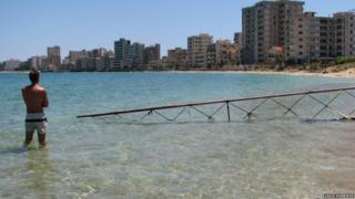 A man looks over the ghost beach ion Varosha.