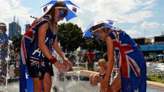 Tennis fans take a dip in a fountain to cool off at the Australian Open.