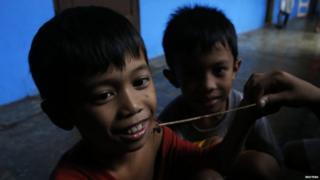 Children playing with spiders an evacuation centre.