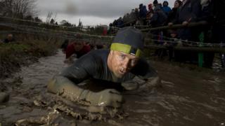 Tough Guy competitor crawls under barbed wire