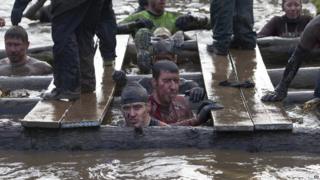 Tough Guy competitors in muddy water