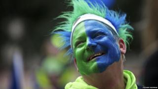 fan with face painted blue and green