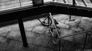 A bicycle tied under the stairs