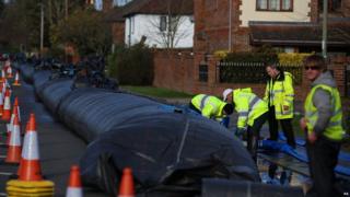 Workers install an aqua dam