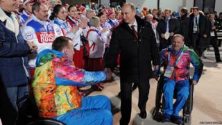 Vladimir Putin shakes hands with athletes