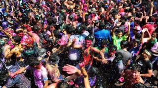 A crowd of people covered in paint