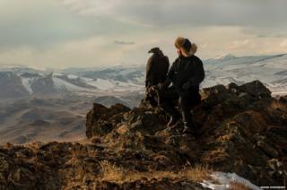 Ashol-Pan on a mountain cliff edge with her eagle