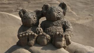 Two koala bears sculpted out of sand