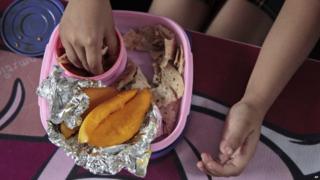 Baani, a 5-year-old Indian schoolgirl, eats her lunch prepared by her mother, consisting of flatbread, a turnip dish and mangoes, at a school in Jammu, India.