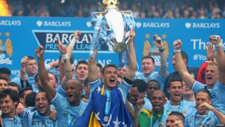Manchester City players celebrate with trophy