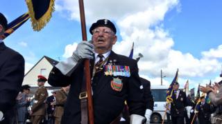 Ex-servicemen take part in a parade in Normandy to commemorate the D-Day landings