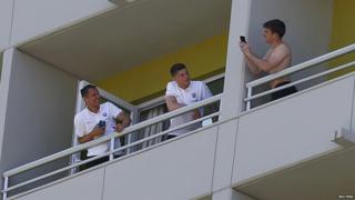 Leighton Baines, Phil Jagielka and Ross Barkley take pictures on their balconies.
