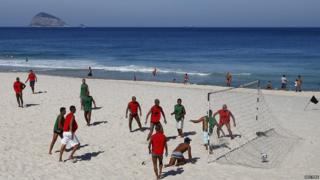 People playing football on beach