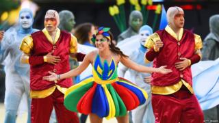 Performers in brightly coloured outfits.