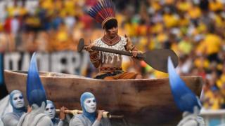 A man in a boat carried along by dancers