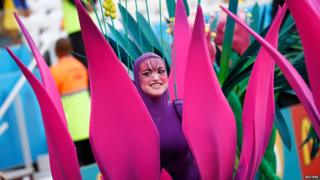 A dancer dressed as a bright pink flower