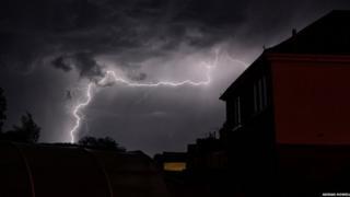 Lightning seen over houses at night