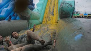 People playing on a mud slide