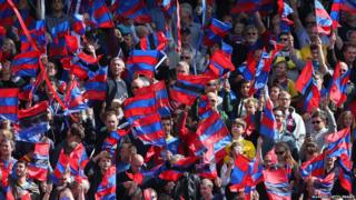 Crystal Palace fans show their colours during the Barclays Premier League match between Crystal Palace and West Ham United at Selhurst Park
