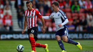 Dusan Tadic of Southampton is marshalled by Craig Gardner of West Brom during the Barclays Premier League match between Southampton and West Bromwich Albion at St Mary's Stadium