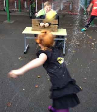 A teacher is splashed with a wet sponge