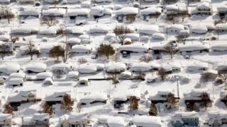 Homes and cars covered in snow