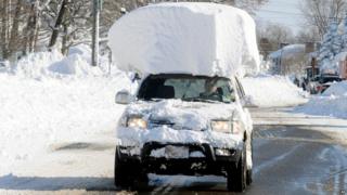 Man driving snow-topped car