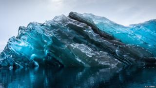 a photograph of an upside down iceberg.