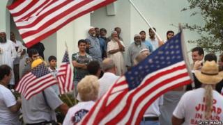 Protesters wave American flags in front of a Florida mosque