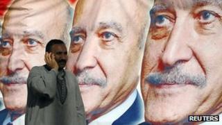 A man walks past election posters for Omar Suleiman in Cairo (6 April 2012)