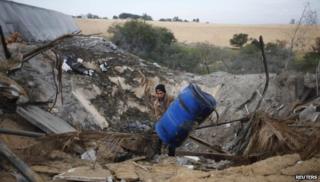 A Palestinian man in the Gaza Strip inspects a site which witnesses said was hit in an Israeli air strike on 14 January 2014