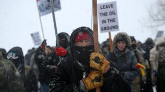 A Native American man leads a protest march with veterans and activists outside the Oceti Sakowin camp where