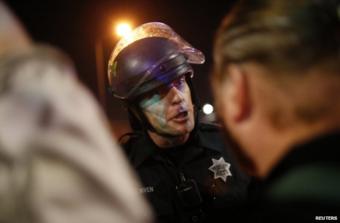 A policeman confronts a protester in Oakland, California, 25 November