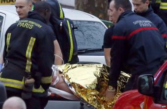 Rescue service workers and firefighters evacuate an injured person on a stretcher near the site of a shooting in Montrouge, south of Paris, 8 January