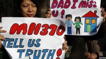 Catherine Gang, whose husband Li Zhi was on board the missing Malaysia Airlines flight MH370, holds a sign during a gathering of family members of the missing passengers outside the Malaysian embassy in Beijing, China, 8 March 2015