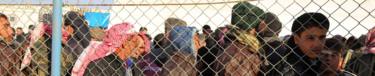 Syrians queue for aid at the Bab al-Salam border gate, on the Syrian border with Turkey, 5 February