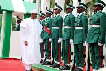 Nigerian president Muhammadu Buhari (L) inspects guards of honour as part of Nigeria's independence anniversary celebrations on 1 October 2015 in Abuja