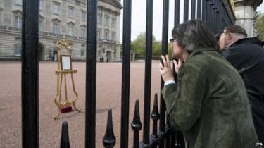 People queue to view the easel containing the announcement of the birth at Buckingham Palace