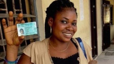 A Nigerian voter poses for a photo with a newly acquired permanent voters card - February 2015