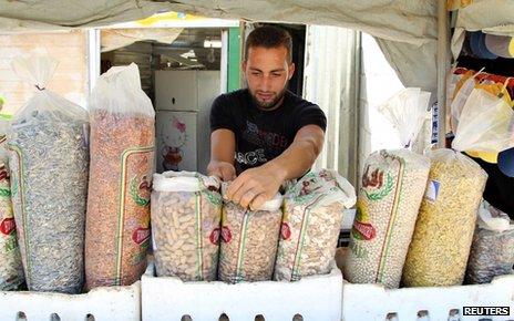 A Syrian refugee displays his goods for sale at Al-Zaatri refugee camp