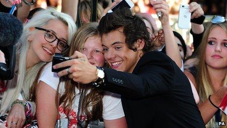 Harry Styles posing for picture with fans