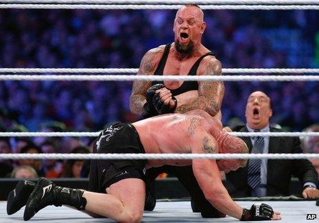 The Undertaker, top, and Brock Lesnar wrestle during Wrestlemania 30