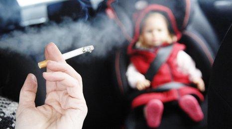 Man smoking in car with child