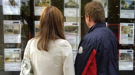 Couple looking in estate agent window