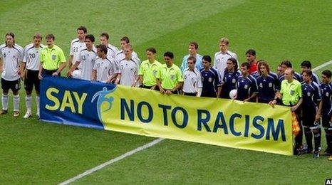 Germany and Argentina players in front of anti-racism banner