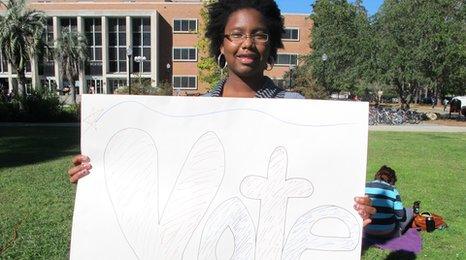 Patrice DeVore with a sign saying 'Vote'