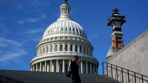 A tourist passes the US Capitol in Washington, DC