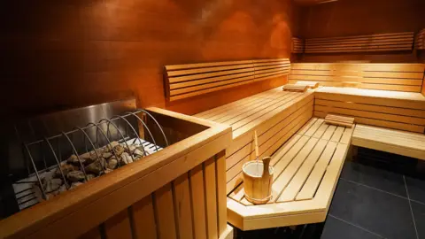 An empty steam room in Japan, which has hot stones in the corner of the photo. 